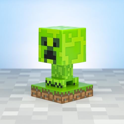 Lampe formet som en grønn, pixellert Minecraft Creeper-figur på kvadratisk base med gress- og jordmønster.