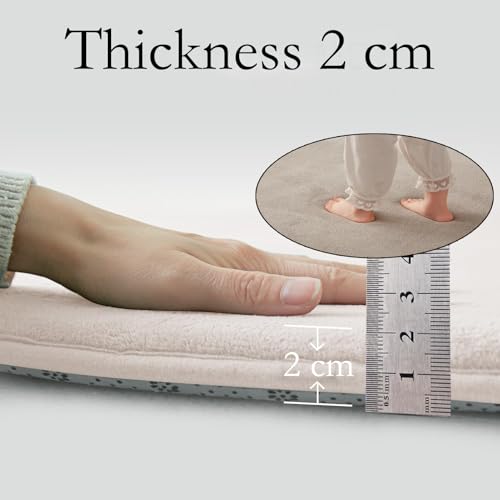 Lekematte Baby i lys beige med hånd som presser ned, linjal viser 2 cm tykkelse, føtter på teppet.