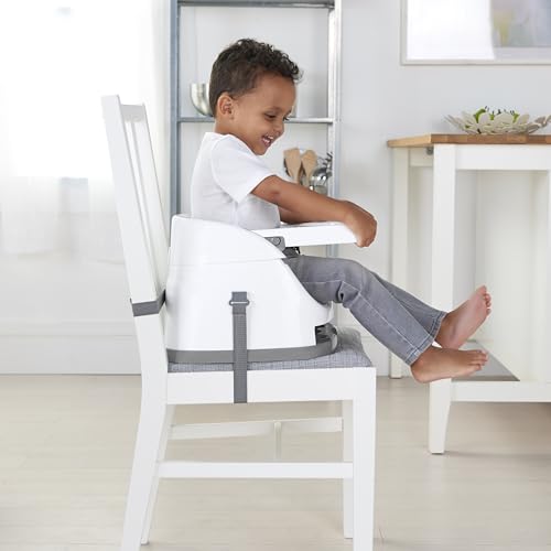 Baby Stol festet til hvit spisestuestol, barn sitter i stolen med grå stropper i lyst rom.