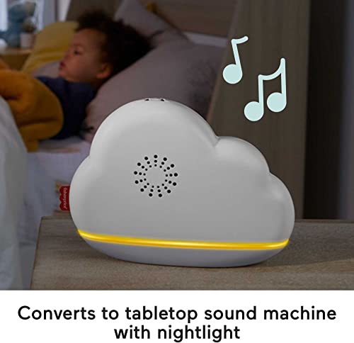 Babymobil Med Musikk, hvit skyformet lydmaskin med gul lysstripe på bord, sovende barn i bakgrunnen.
