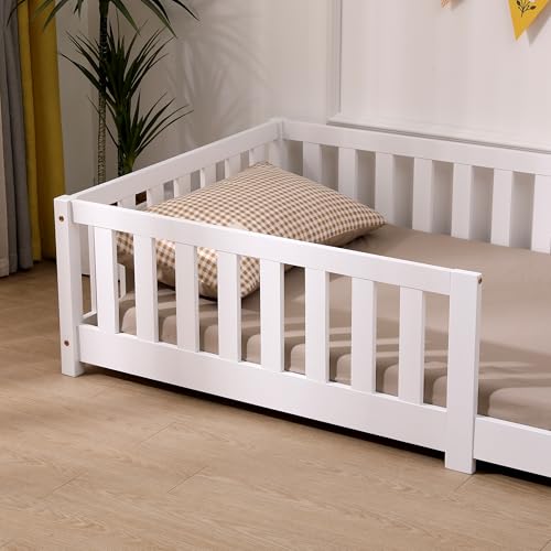 Barneseng med hvit treramme, beige madrass og rutete pute, sett fra siden og litt ovenfra. Minimalistisk stil.