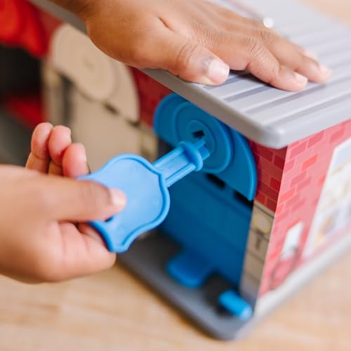 Treleke garasje med blå nøkkel som vris inn i lås på siden av plastlekehuset med mursteinsmønster.