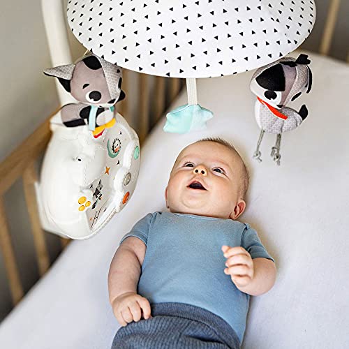 Uro Baby med projektor og nattlys henger over sprinkelseng, baby ser opp på grå og svarte kosedyr.