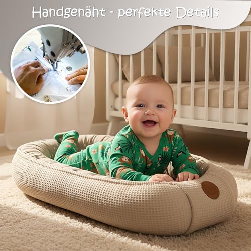 Babyrede i beige vaffelmønstret stoff med baby, rund lærpatch på kanten og nærbilde av håndsydd søm.