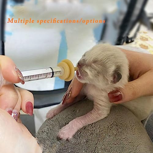 Strikkepinne liten kattunge mates med melk fra plastiksprøyte, holdt av person, fokus på kattunge og sprøyte.