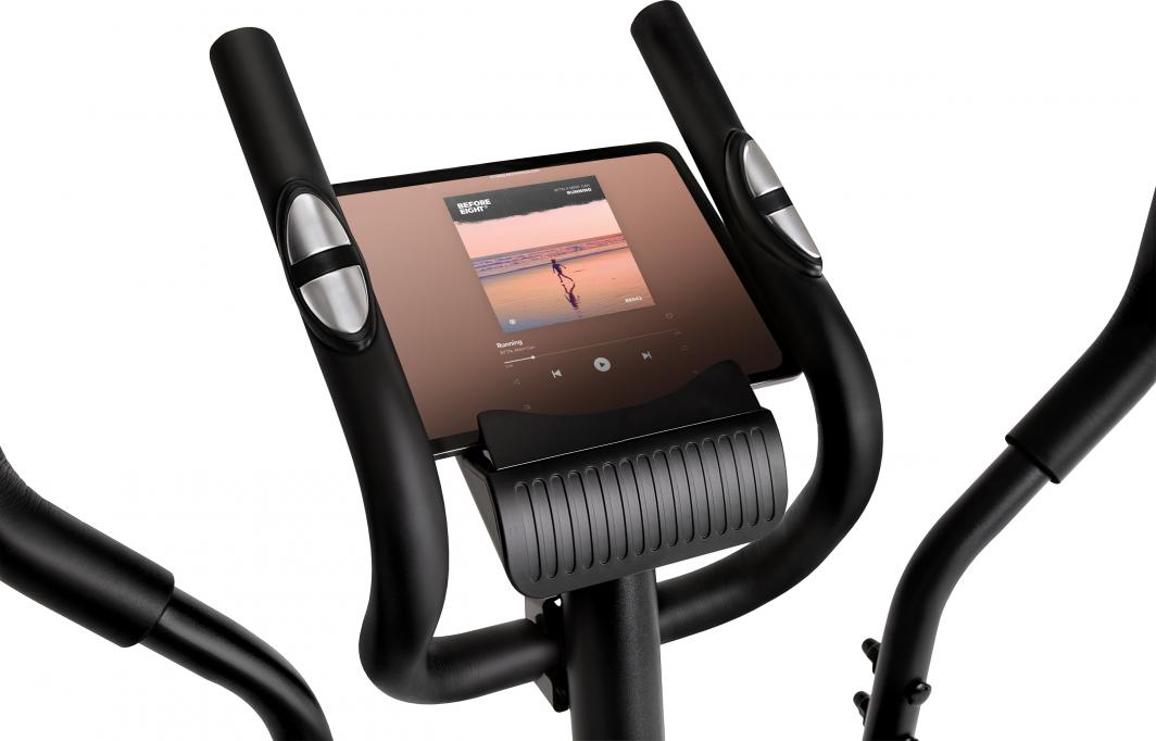 Orbitrek med buede håndtak, sølvfargede pulssensorer og nettbrettholder, nærbilde av LCD-displayet.