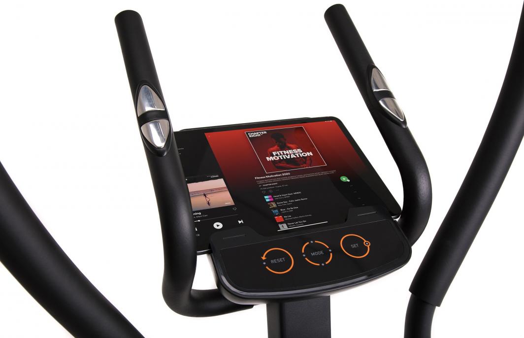 Ellipsemaskin i sort og sølv med store pedaler, stabil ramme og digitalt display, avbildet fra siden.