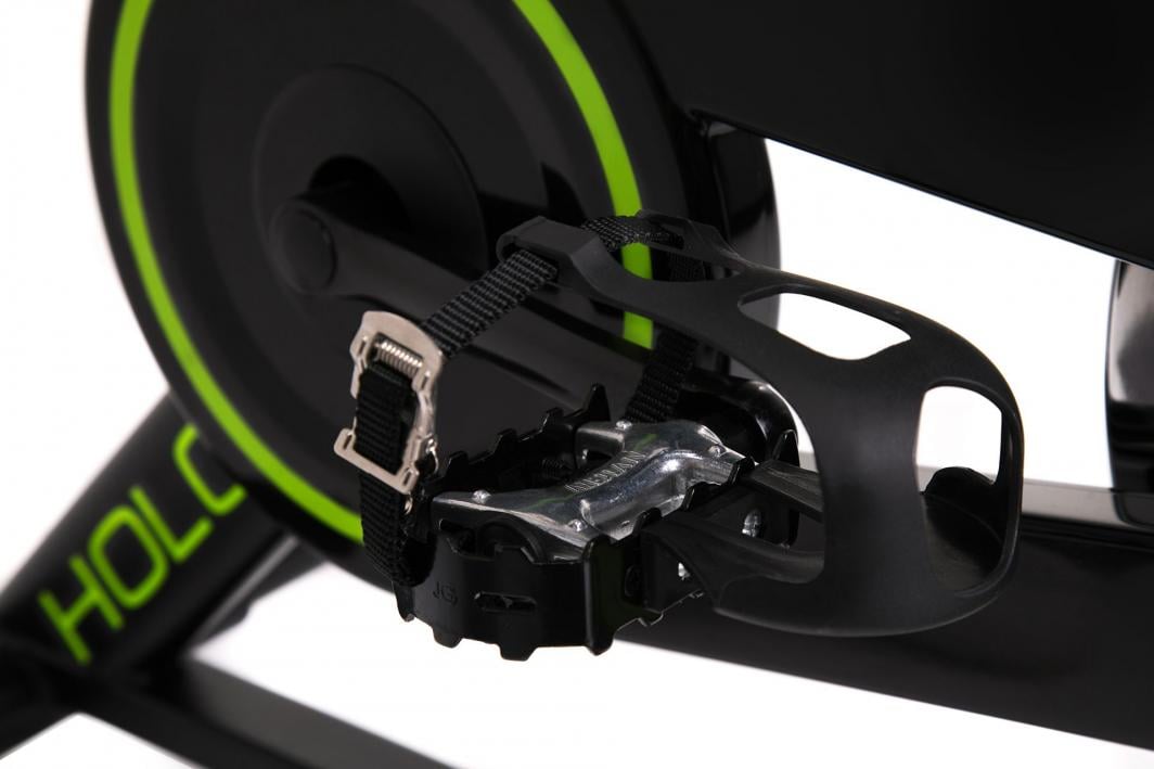 Spinningsykkel med sykkelpedeal, tårem og justerbar stropp, sort og sølv med grønn dekorlinje på krankhuset.