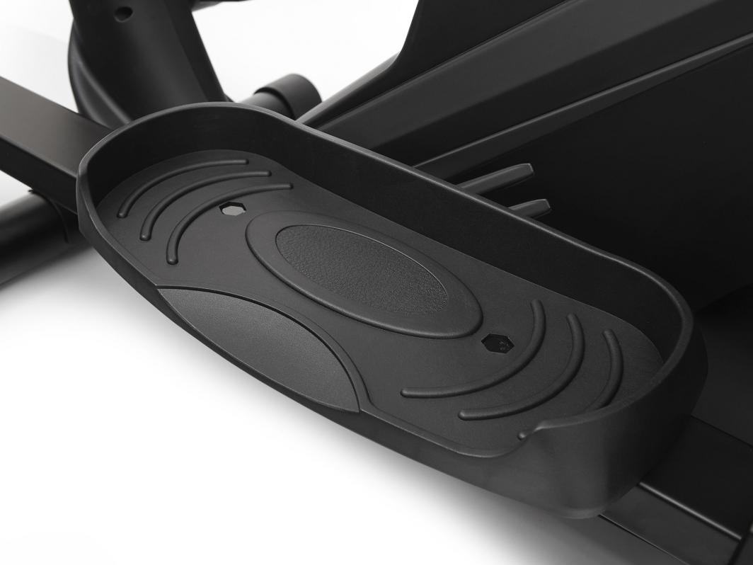 Orbitrek sort fotplate i plast med forhøyet kant og sklisikkert mønster, vist fra skrå nærvinkel.