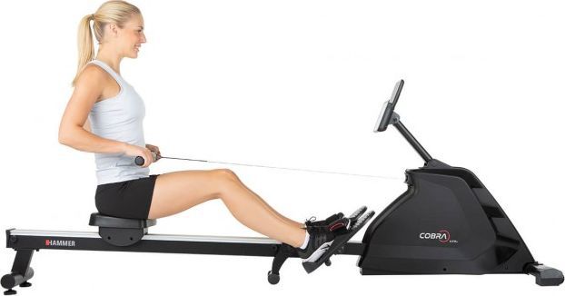 Romaskin Sammenleggbar i svart med sølvdetaljer, person trener, synlig skjerm, sete, fotstøtter og håndtak.