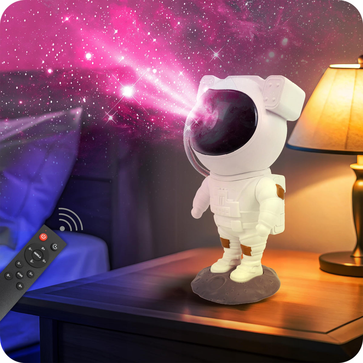 Stjernehimmel Lampe i form av astronaut på grå base, projiserer rosa stjerner på veggen, fjernkontroll vises.