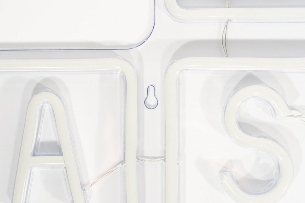 Tredemølle neonskilt WASD med nærbilde av hvite neonlysrør som former bokstavene A og S.