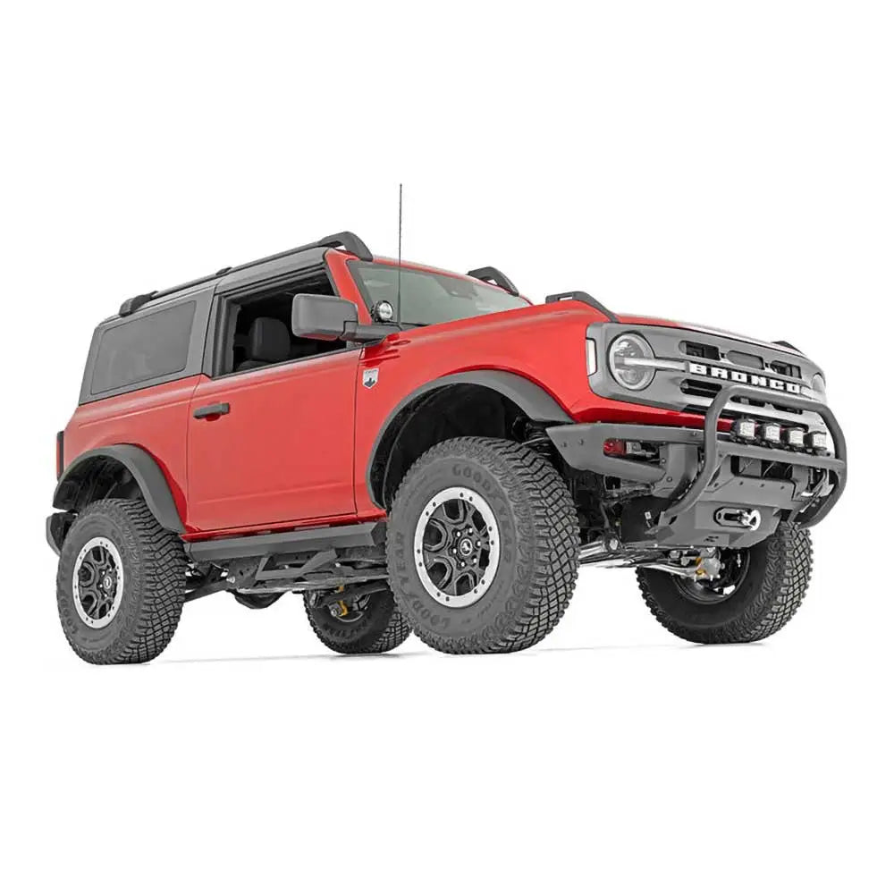 Kufanger til Ford New Bronco med store terrengdekk og ekstra lys, vist skrått forfra mot hvit bakgrunn.