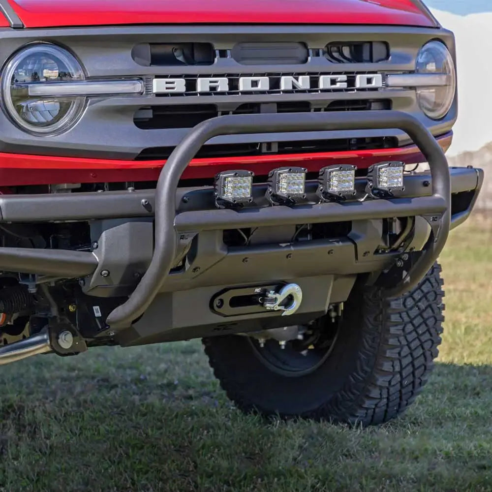 Bullbar for Ford New Bronco 2 D med fire LED-lys, kraftig bøyle og vinsjkrok foran på rød bil.