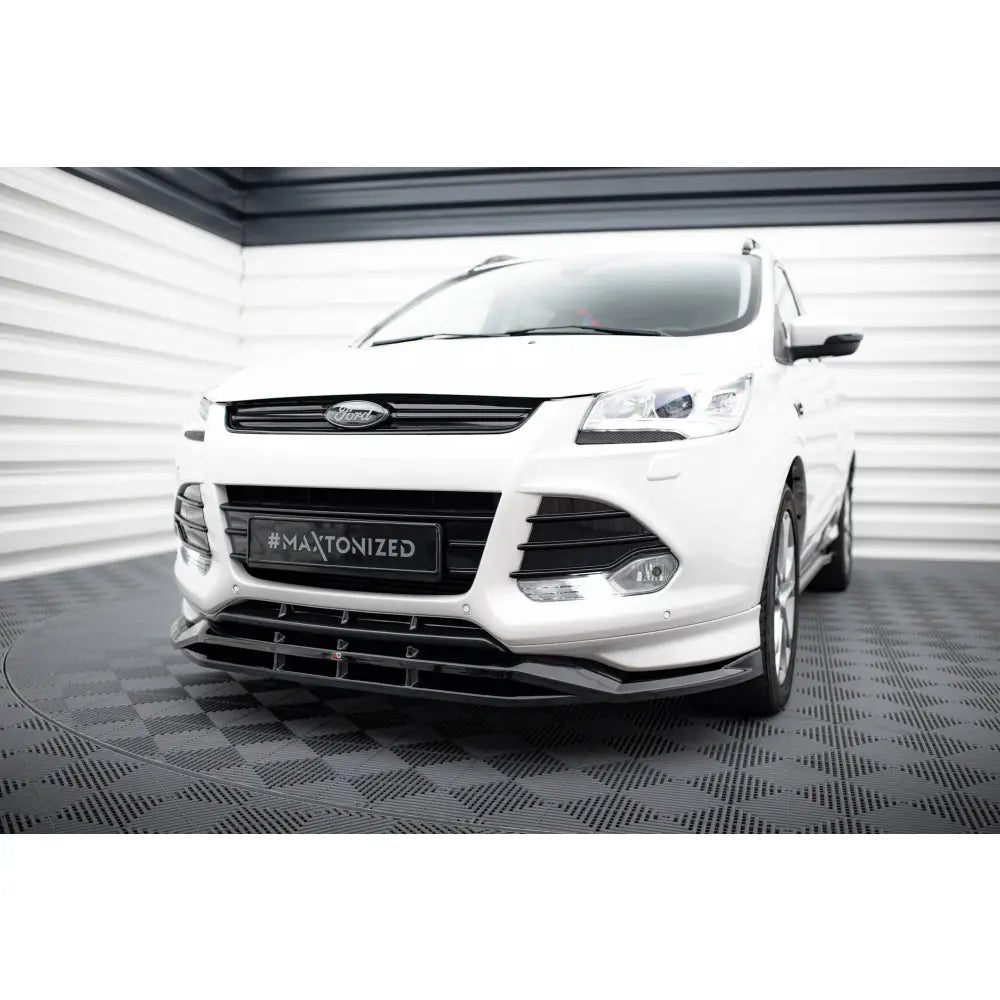 Frontspoiler til Ford Kuga ST-Line Mk2 med svarte detaljer og sporty styling, sett forfra i lyst rom.
