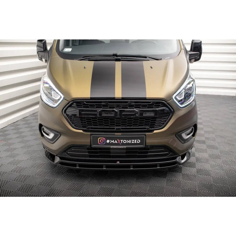 Frontleppe Ford Tourneo Custom Mk1 Facelift med svarte striper og markante frontlykter fotografert forfra.