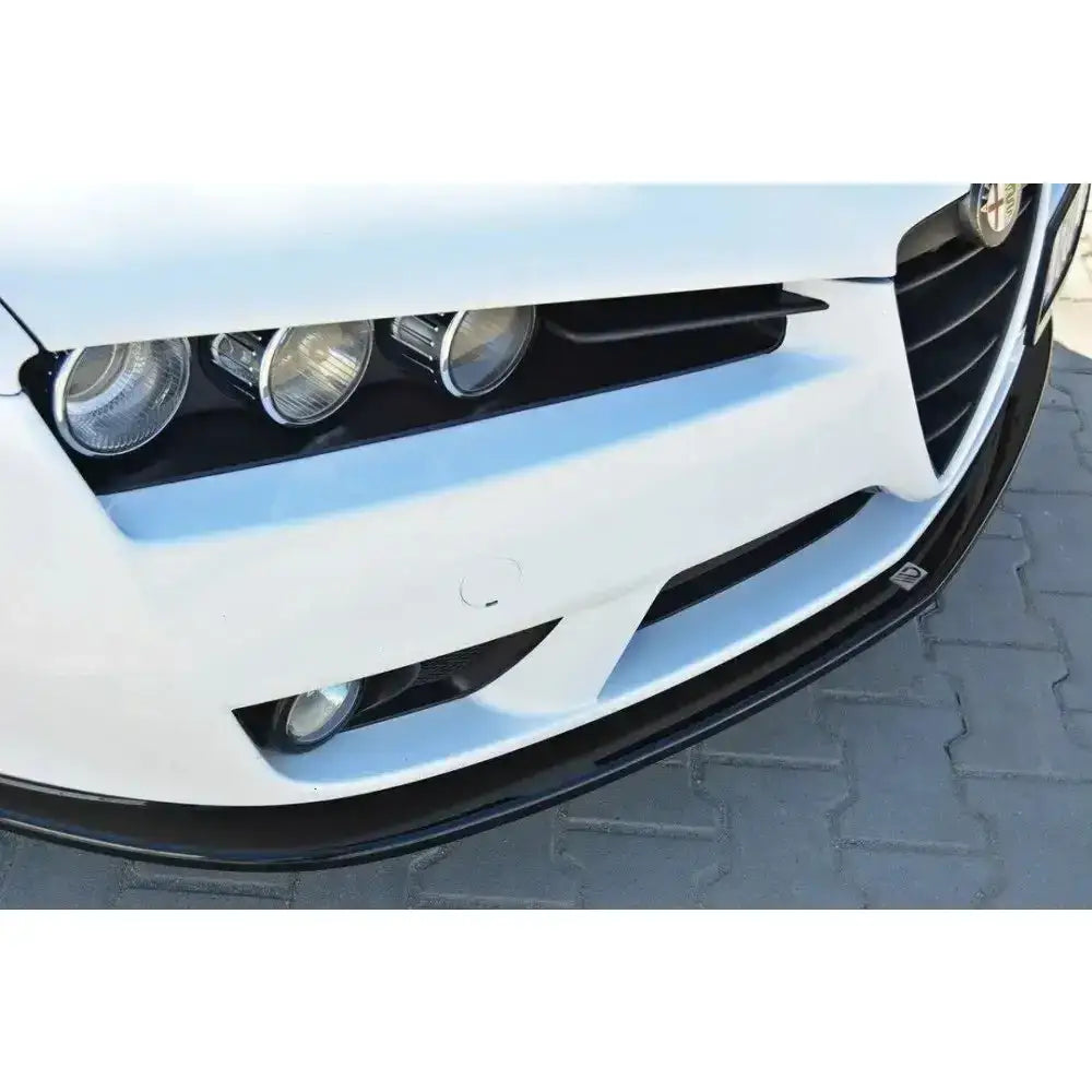 Front splitter på Alfa Romeo Brera, nærbilde av sort leppe under hvit front med frontlykter.