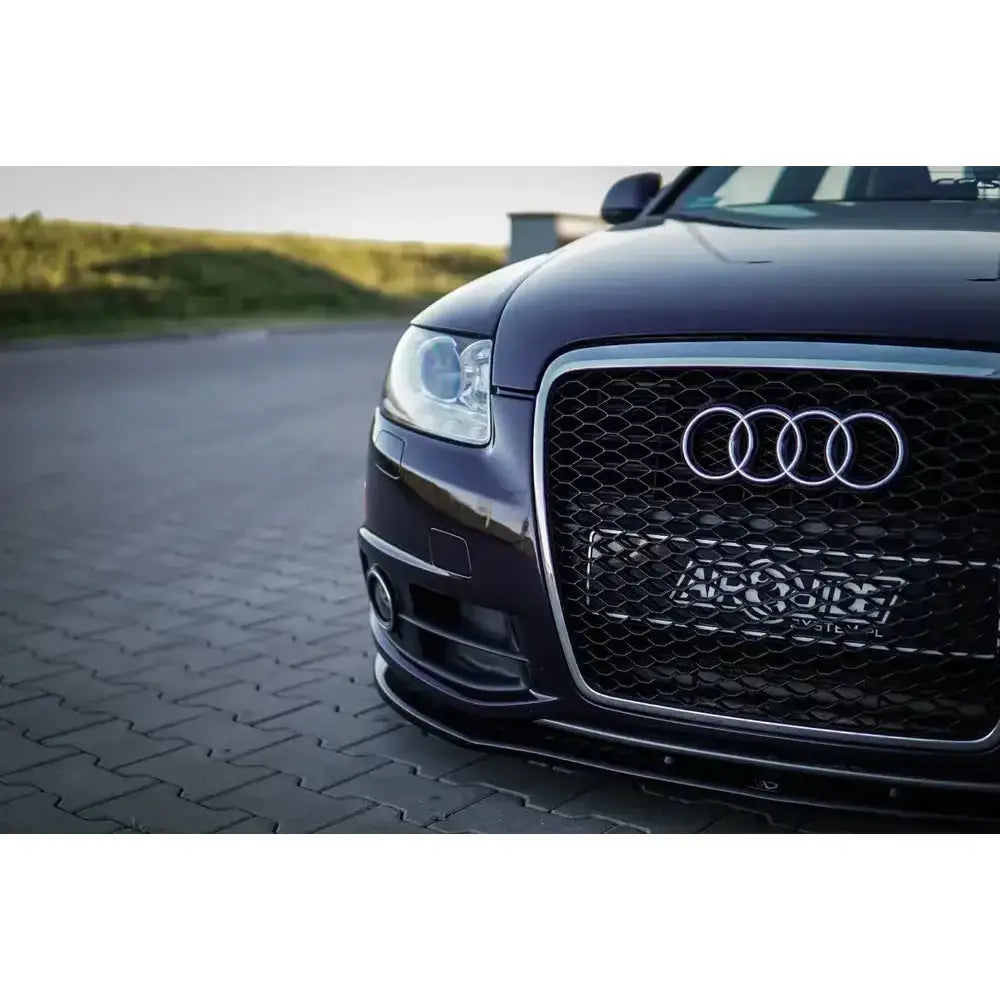 Frontspoiler Audi A6 C6 S-Line FL sedan i sort med bikubemønstret grill og kromdetaljer, nærbilde fra siden.