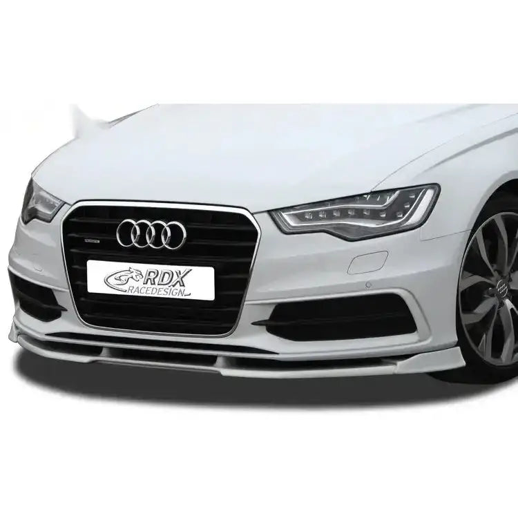Frontleppe Audi A6 C7 Vario X montert på hvit bil med svart grill og kromdetaljer, sett skrått forfra.