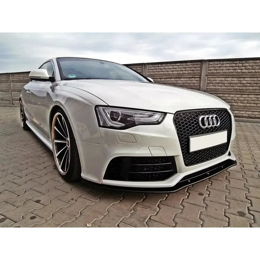 Front splitter på hvit Audi RS5 8T med store aluminiumsfelger og sort bikakerutet grill.