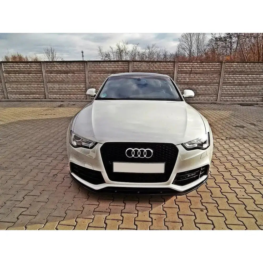 Frontleppe Audi RS5 8T montert på hvit bil sett forfra med sort grill og Audi-logo utendørs.
