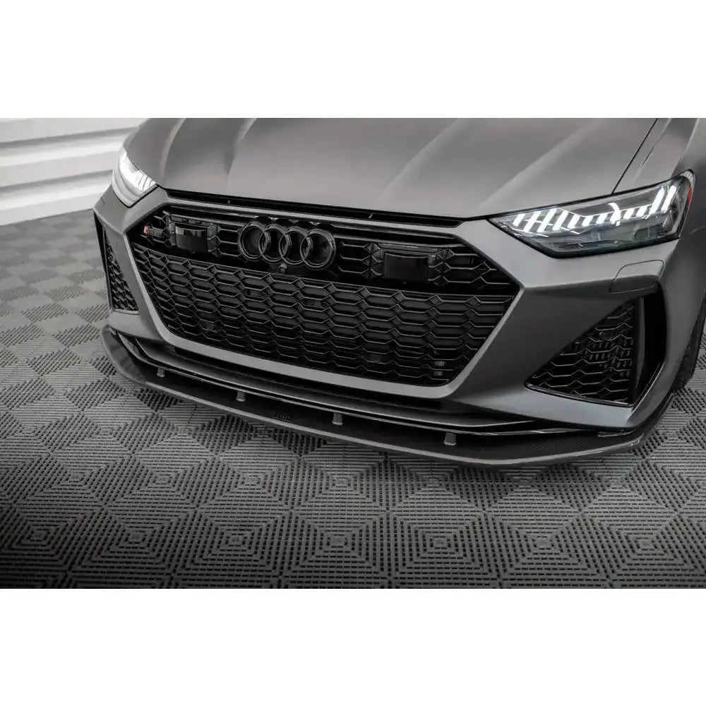 Frontsplitter til Audi RS6 C8 i karbon under sort grill og markerte frontlykter på grå bil.