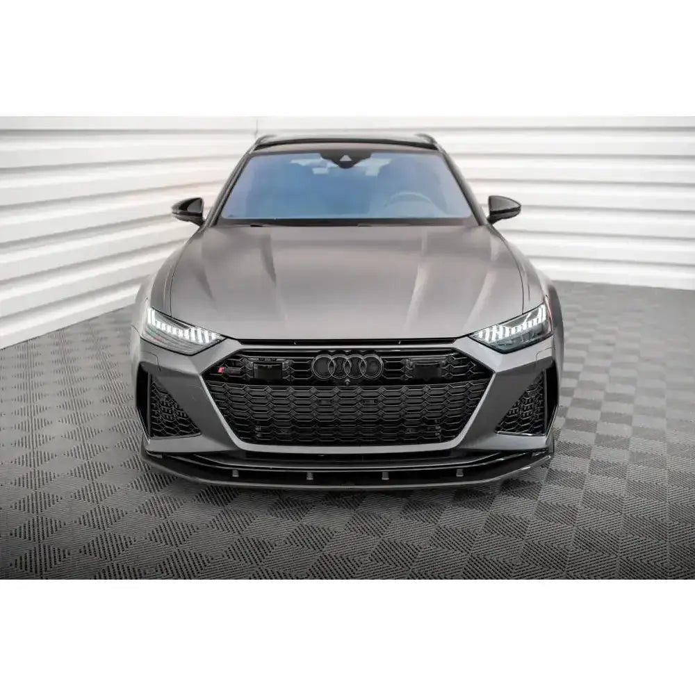 Frontspoiler på Audi RS6 C8 i matt grå med svart grill og LED-lys, fotografert innendørs.