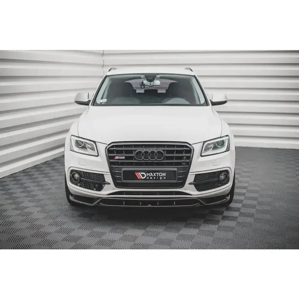 Frontspoiler Audi SQ5 Mk1 montert på hvit bil sett forfra med sort grill og lyse omgivelser.