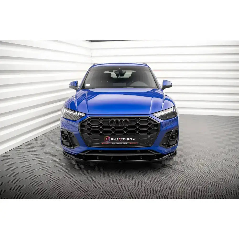 Frontspoiler Audi SQ5/Q5 S-Line Facelift på blå bil sett forfra i lyst showroom med rutet gulv.