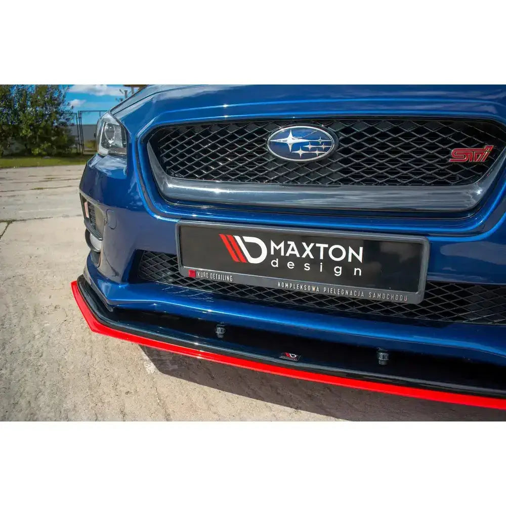 Front lip på Subaru Wrx Sti med svart og rød splitter, sett forfra fra lav vinkel med synlig grill.
