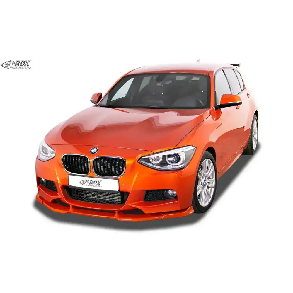 Frontspoiler på BMW 1 F20/F21 11-15 M-Tech, oransje bil med svart grill og sølvfelger.