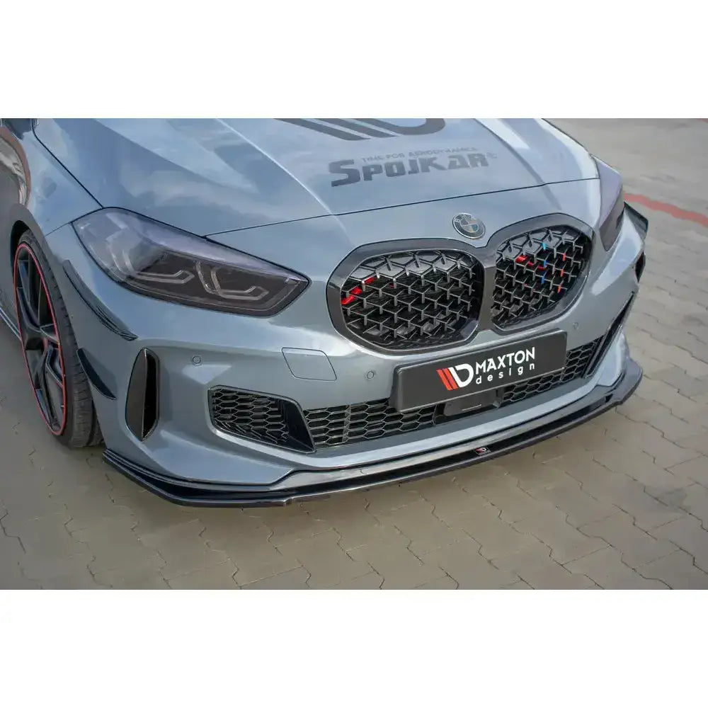 Frontspoiler til BMW 1 F40 M-Pack med sort finish, montert på grå bil med rutemønstret grill.