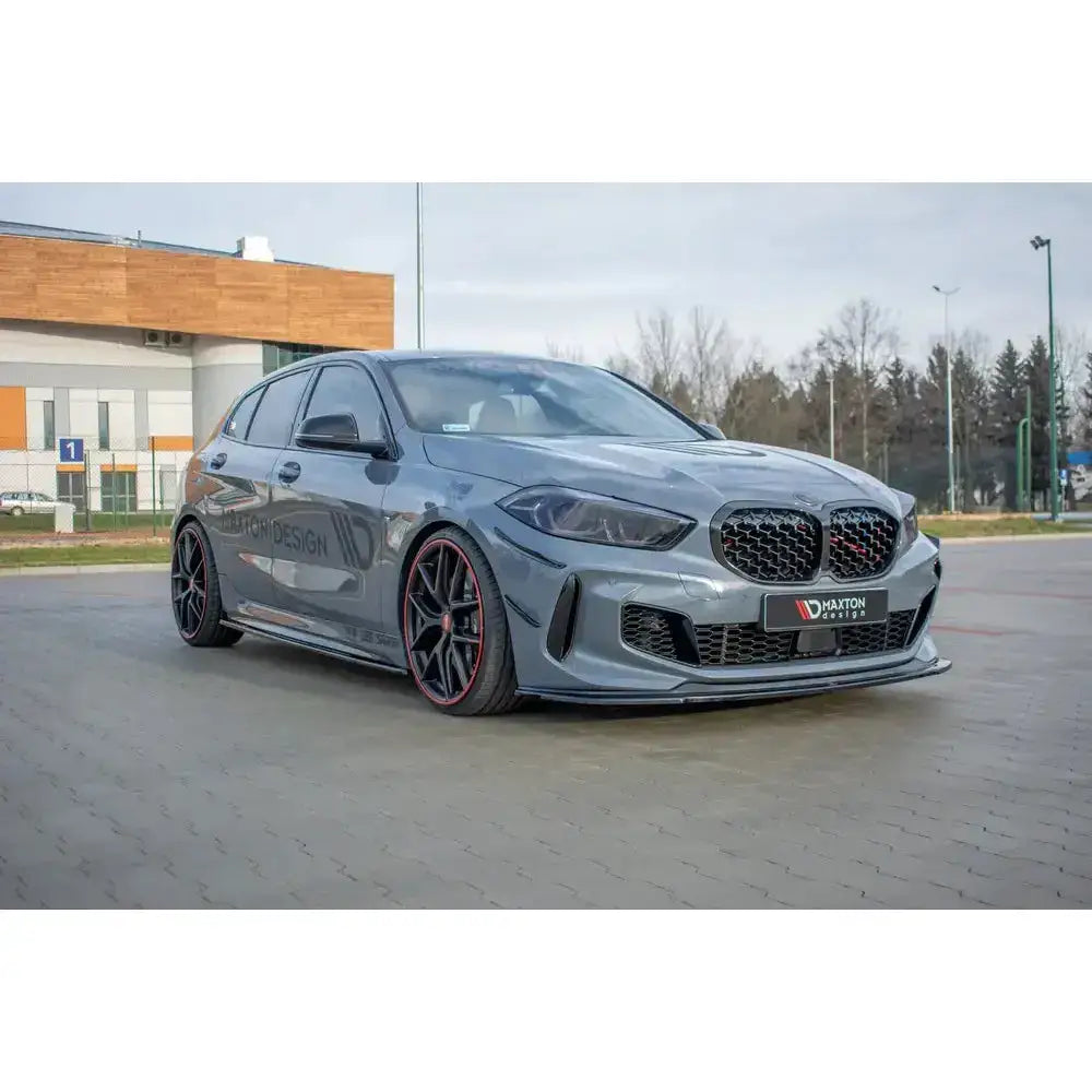 Front lip på grå Bmw 1 F40 M-Pack med sorte felger, røde detaljer og sporty frontspoiler.