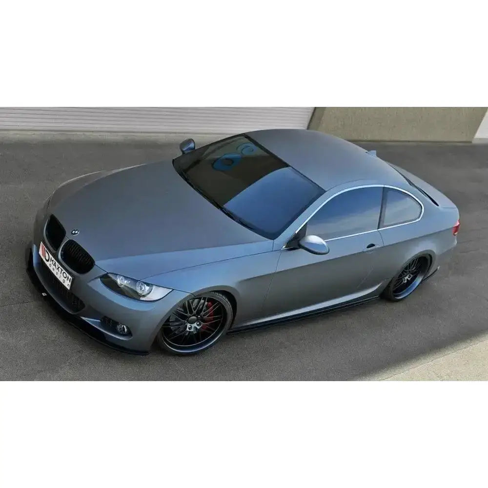 Frontspoiler på grå BMW 3 E92 Mpack med sotede ruter og svarte felger, parkert på asfalt.