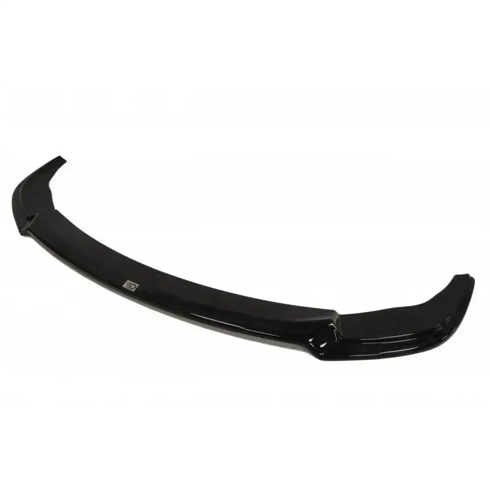 Front lip til BMW 5 E60/61 M-Pack, sort buet plastdel med metallogo, sett skrått ovenfra.