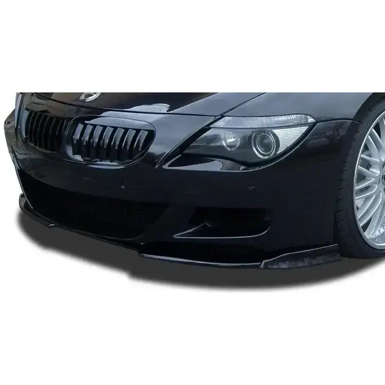 Frontleppe BMW 6 E63 M6 i sort karbonfiber, montert på bil, synlig grill, frontlykt og felg.