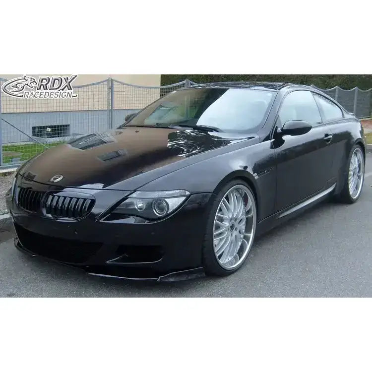 Frontsplitter på BMW 6 E63 M6 med lav sort frontspoiler og store sølvfelger, parkert på asfalt.