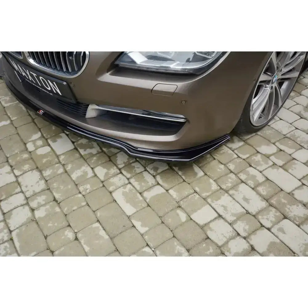 Frontsplitter til Bmw 6 Gran Coupé i sort plast montert på brun bil, sett skrått forfra.