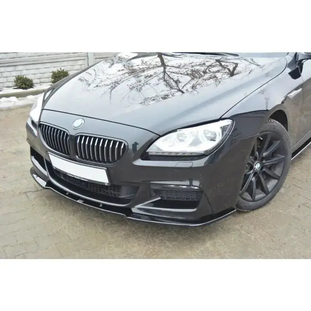 Frontspoiler på Bmw 6 Gran Coupé Mpack, sort bil skrått forfra med grill og høyre frontlykt synlig.