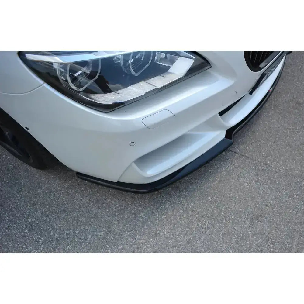 Frontsplitter på Bmw 6 Gran Coupé Mpack, svart spoiler under høyre frontlykt på hvit bil.