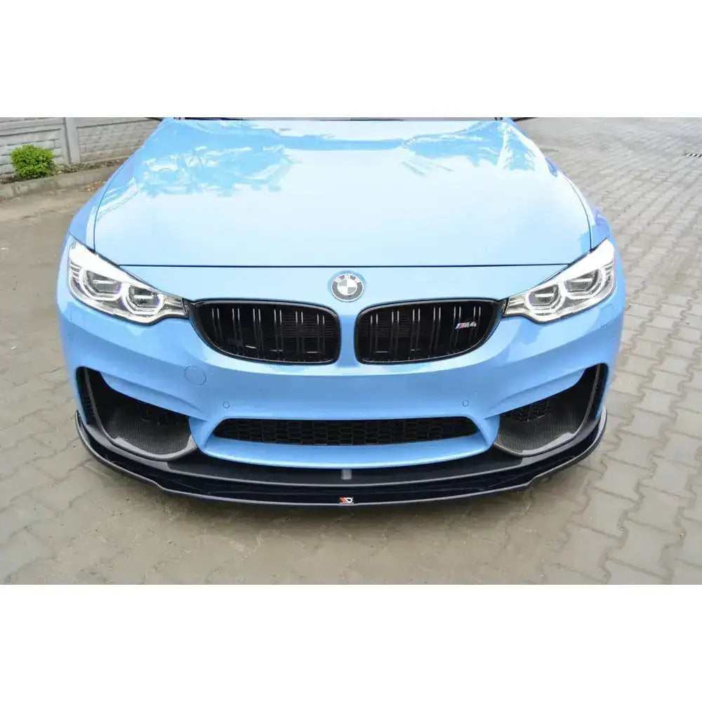 Frontsplitter på Bmw M4 F82 M-Performance, sort spoiler foran lyseblå bil med synlig BMW-emblem.