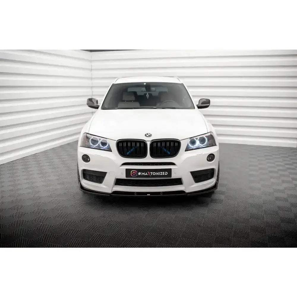 Frontspoiler til BMW X3 F25 M-Pack sett forfra med LED-lykter og sorte detaljer mot lys bakgrunn.