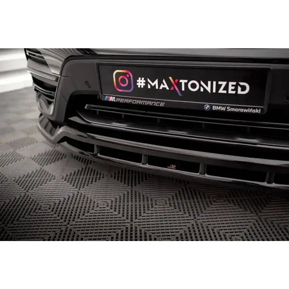 Front lip til BMW X3 G01, sort plastspoiler med luftinntak og nummerplatholder sett forfra.