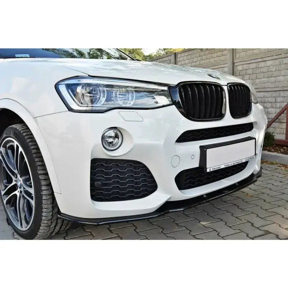 Frontspoiler på Bmw X4 M-Pack sett fra venstre front med sorte detaljer og delvis synlig emblem.