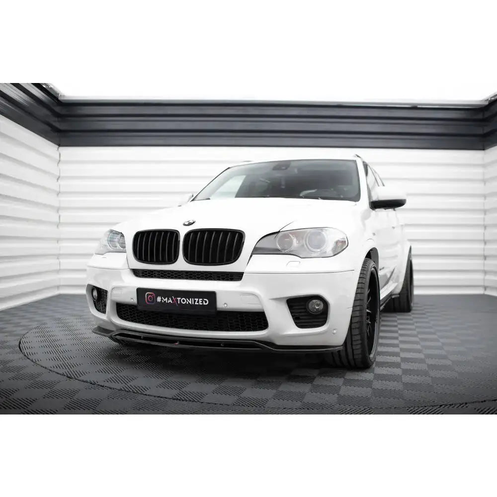 Frontspoiler på hvit BMW X5 E70 Facelift M-Pack med sorte felger og markante luftinntak.