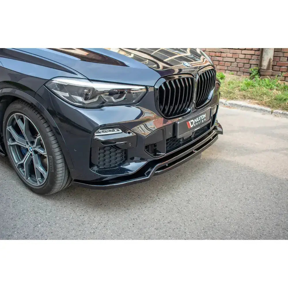 Frontsplitter på Bmw X5 G05 M-Pack med sort grill og sportslige detaljer, parkert på asfalt.