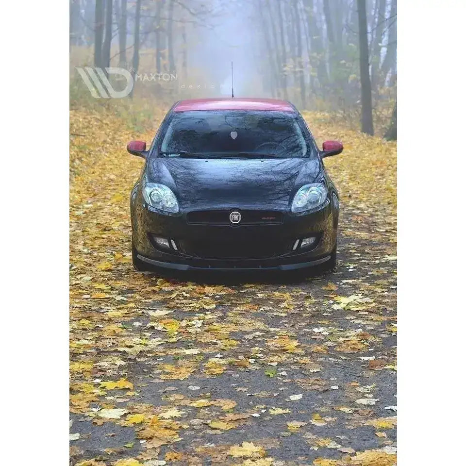 Frontsplitter på Fiat Bravo II, sort bil med rødt tak sett forfra, parkert på vei med høstblader.