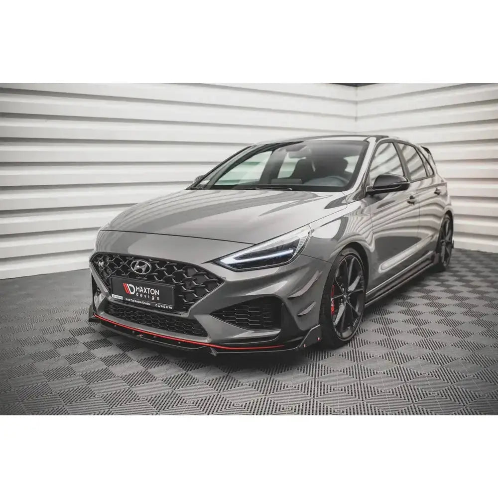 Front lip på Hyundai I30 N Hatchback Mk3 Facelift med svarte felger og rød stripe langs frontsplitteren.
