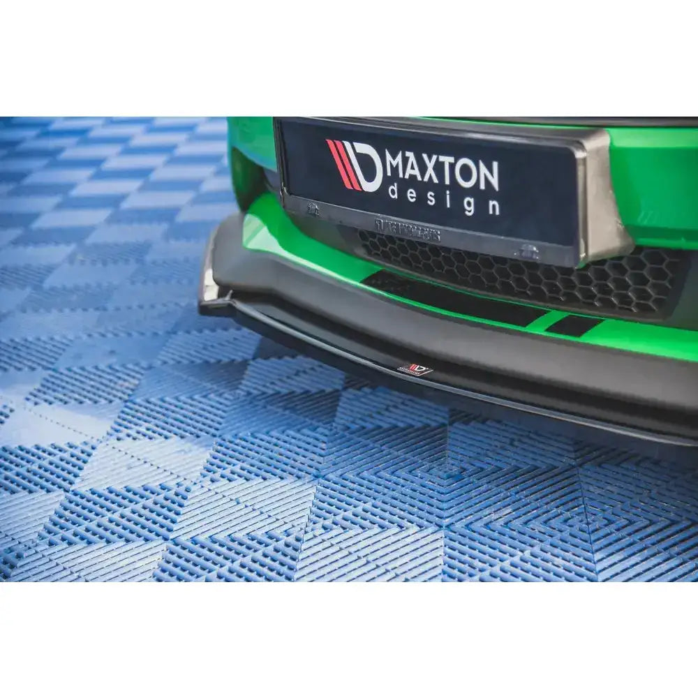 Frontsplitter til Ford Mustang GT MK6 Facelift, svart med logo, montert på grønn bil, sett forfra.