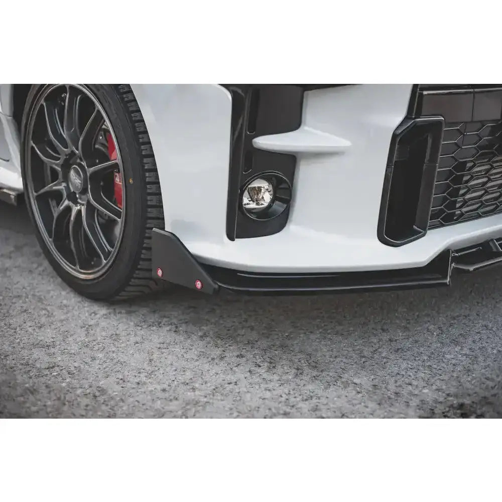 Frontsplitter på Toyota GR Yaris Mk4 med svart felg, rød bremsekaliper og hvit støtfanger.